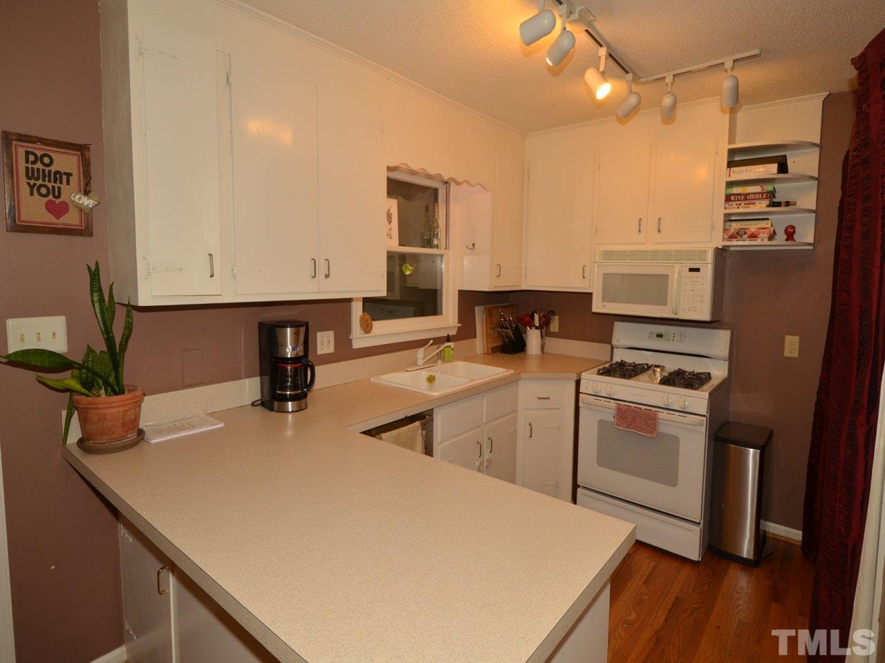 2821 Old Orchard Road Raleigh, NC 27607 - Photo 12 of 25 a kitchen with stainless steel appliances granite countertop a sink a stove and a refrigerator
