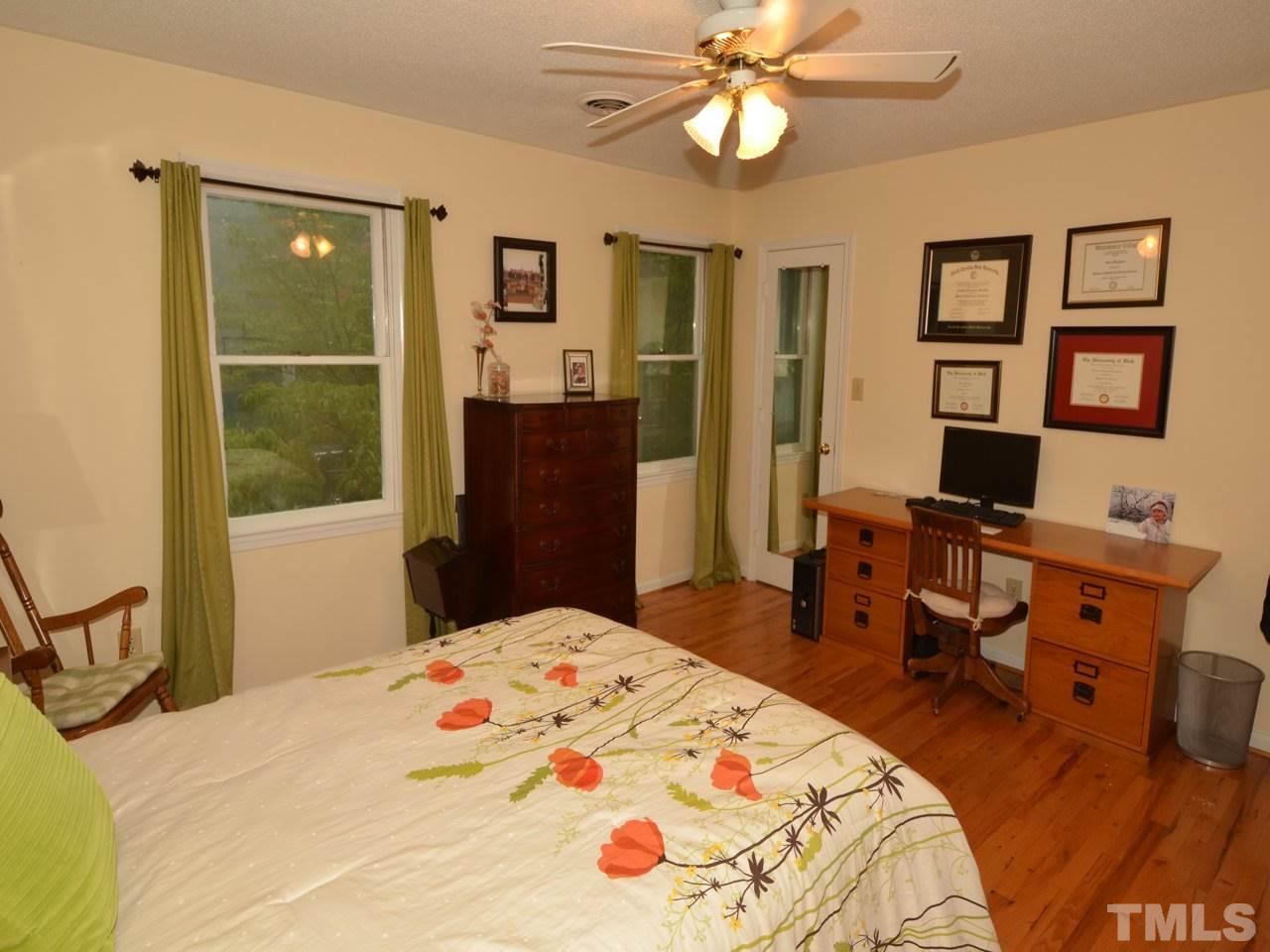 2821 Old Orchard Road Raleigh, NC 27607 - Photo 17 of 25 a bedroom with a bed and wooden floor