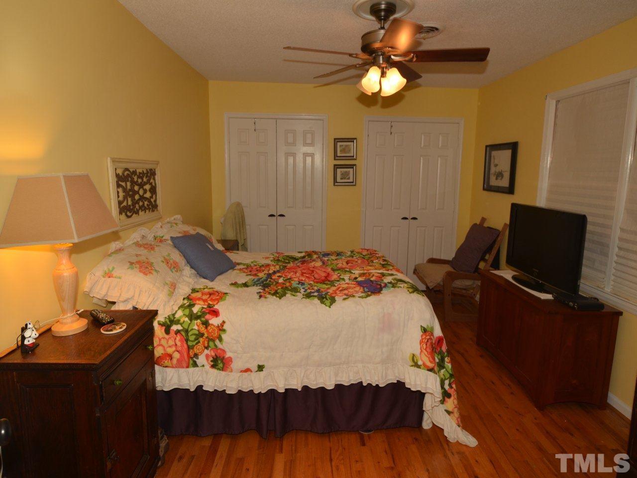 2821 Old Orchard Road Raleigh, NC 27607 - Photo 21 of 25 a bedroom with a bed and a chandelier