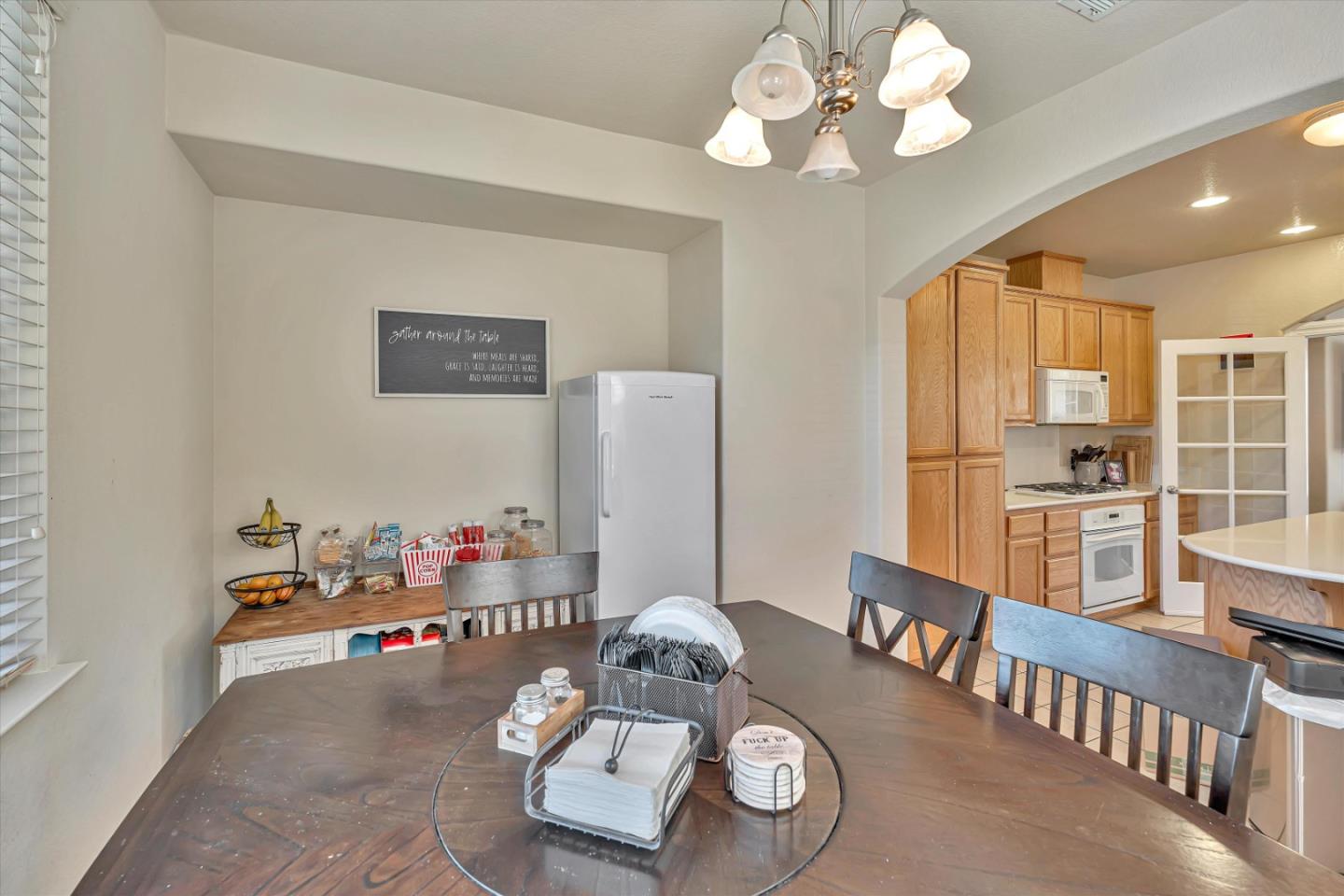 390 Munter Street Manteca, CA 95337 - Photo 9 of 26 a view of a dining room with furniture a chandelier and wooden floor
