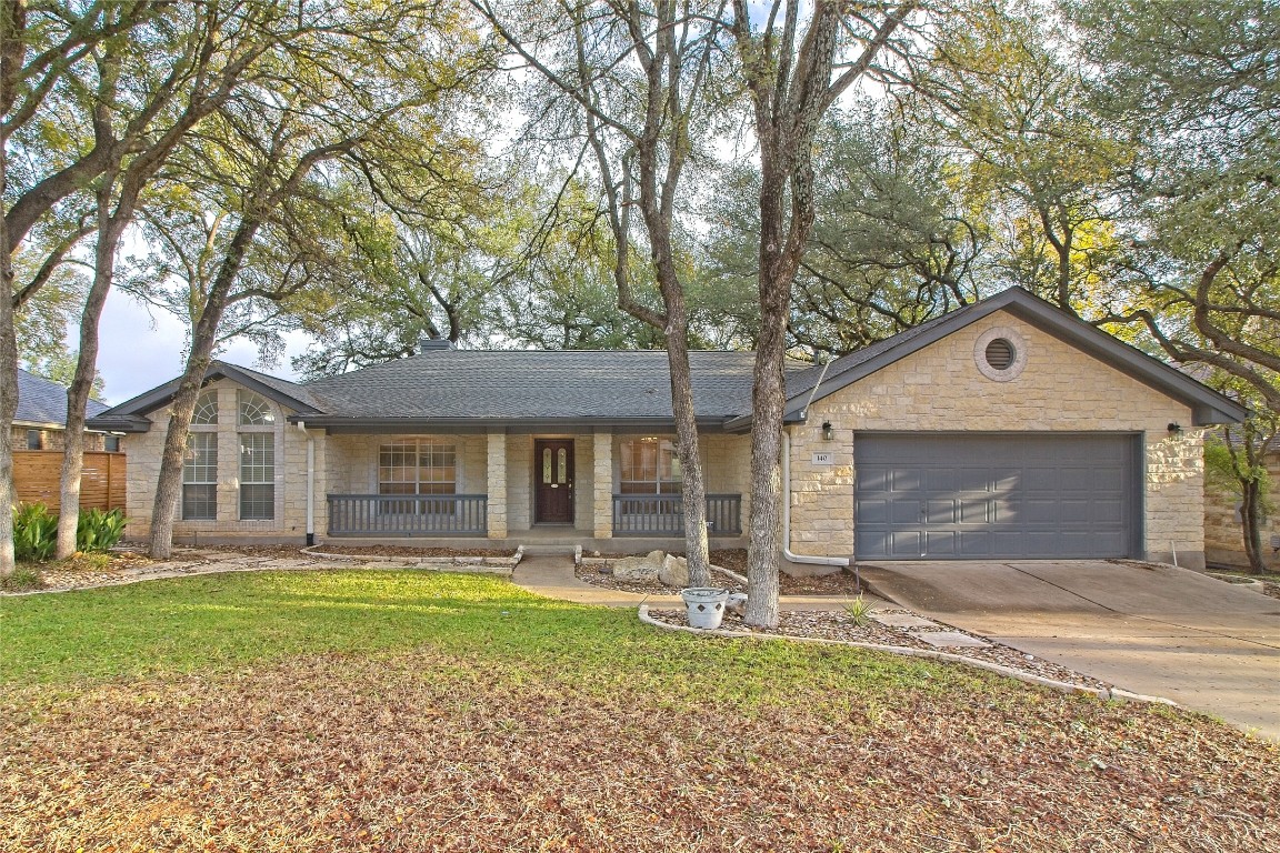 a front view of a house with a yard and trees