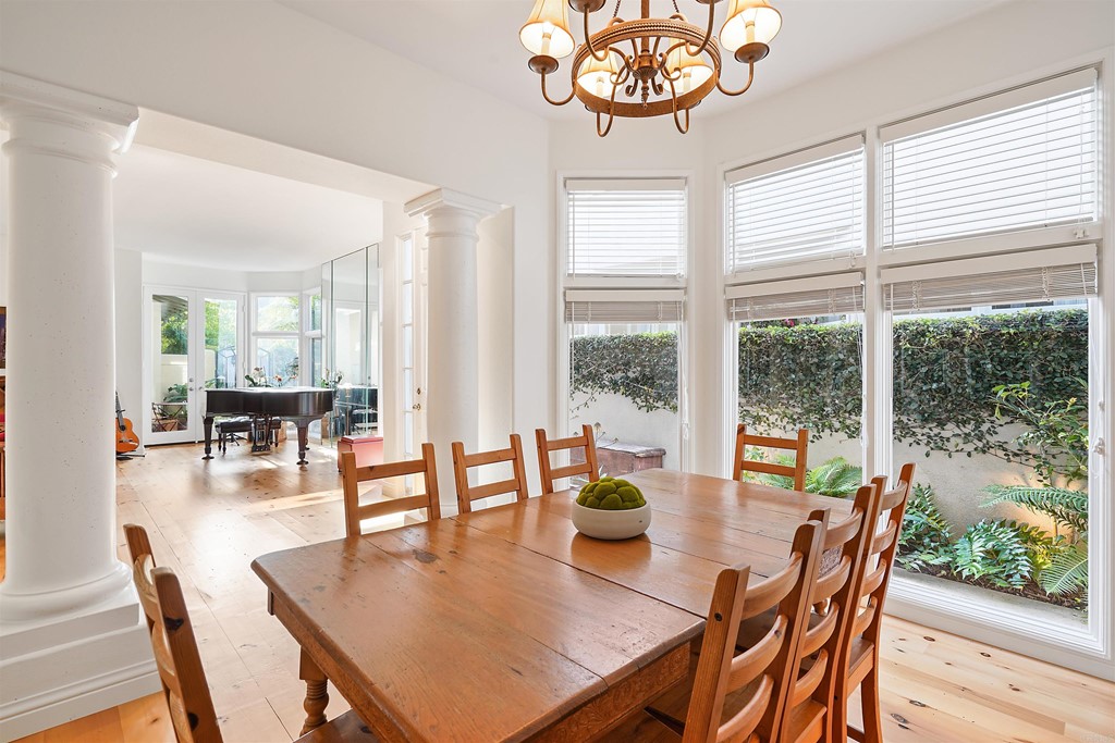 9735 Claiborne Square La Jolla, CA 92037 - Photo 16 of 60 a dining room with furniture a chandelier and wooden floor