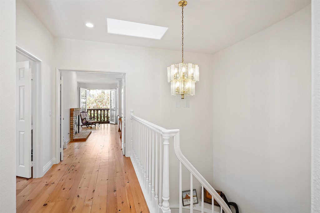 9735 Claiborne Square La Jolla, CA 92037 - Photo 34 of 60 a view of a hallway with wooden floor and chandelier