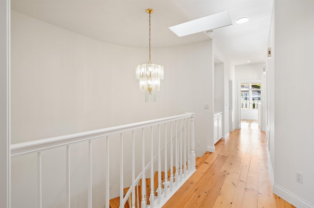 9735 Claiborne Square La Jolla, CA 92037 - Photo 42 of 60 a view of a hallway with wooden floor and staircase