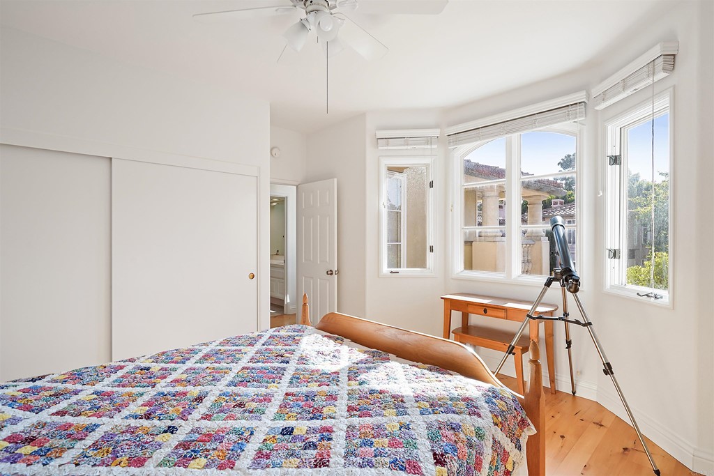 9735 Claiborne Square La Jolla, CA 92037 - Photo 48 of 60 a bedroom with a bed and a chandelier