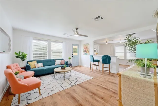 a living room with furniture a dining table a lamp and a potted plant