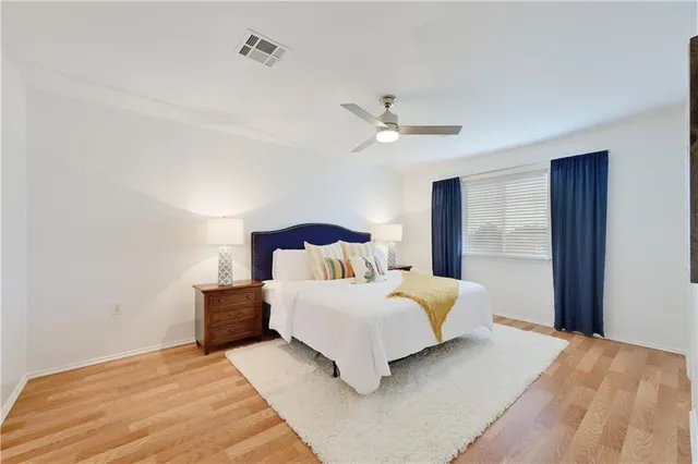 a bedroom with a large bed and a chandelier
