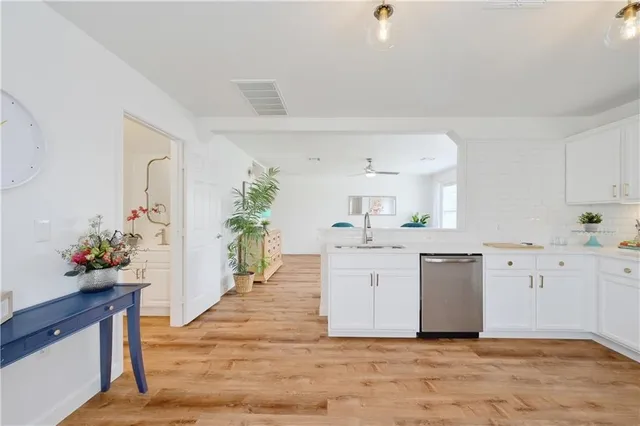 a large white kitchen with cabinets and wooden floor