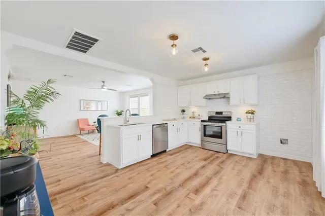 a kitchen with a refrigerator sink and white cabinets