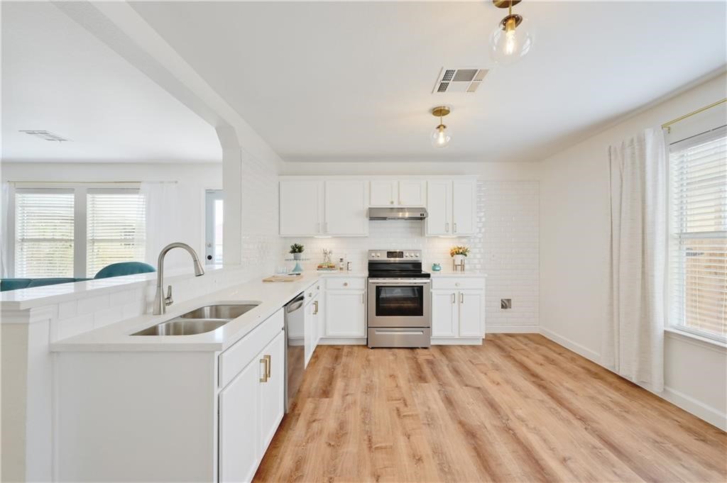 12329 Sky Harbor Drive Del Valle, TX 78617 - Photo 20 of 29 a kitchen with white cabinets and appliances