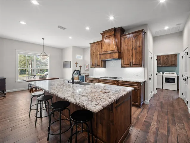 a kitchen with granite countertop stove and cabinets