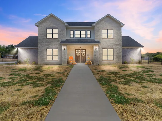a view of a big house with a big yard and large trees