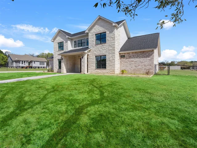 a view of a white house with a big yard and large trees