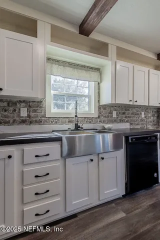 a kitchen with granite countertop a sink cabinets and wooden floor