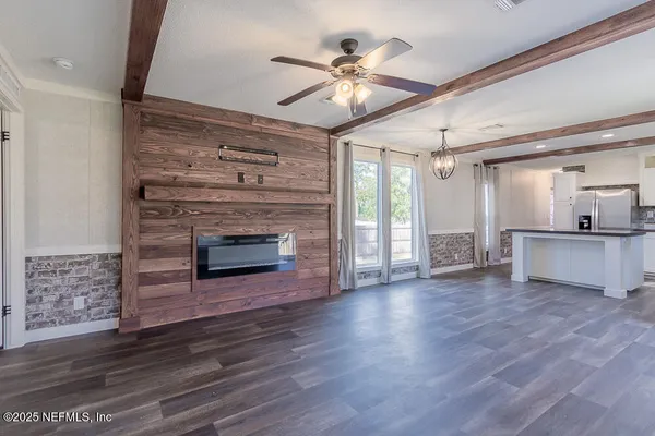 a view of a livingroom with a fireplace a ceiling fan and fire place