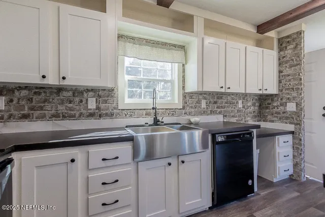 a kitchen with granite countertop white cabinets and sink