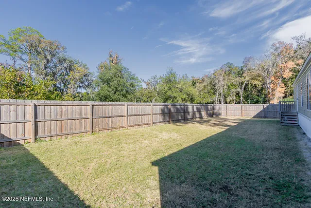 a view of a backyard with fence