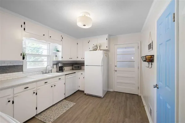 a kitchen with white cabinets and white appliances