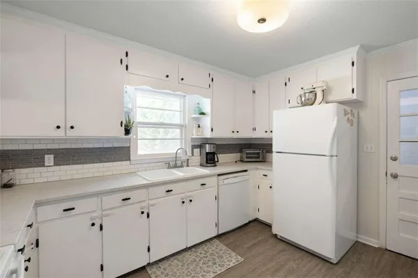 a kitchen with cabinets appliances a sink and a window