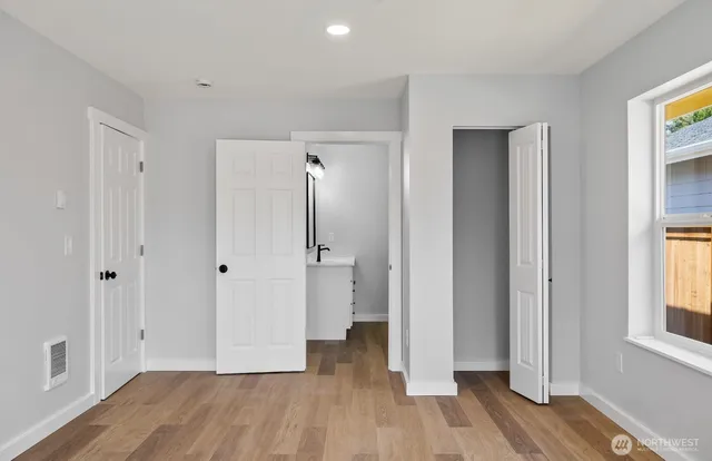 a view of empty room with wooden floor and window