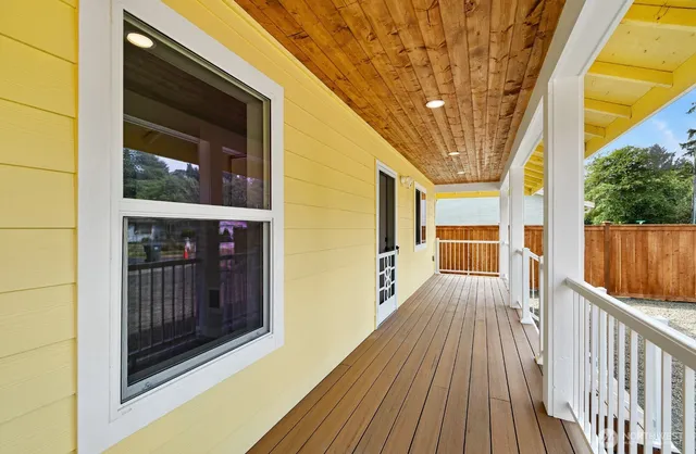 a view of a porch with wooden floor and door