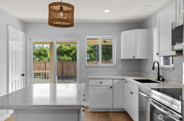 a kitchen with stainless steel appliances granite countertop a stove a sink and a granite counter tops