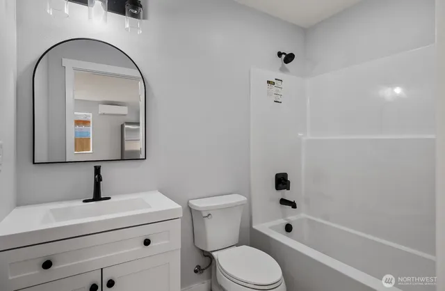 a bathroom with a toilet sink a mirror a vanity and shower