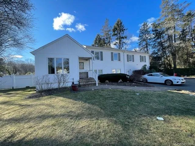a front view of a house with a garden and trees