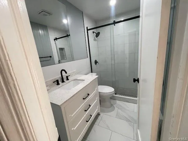 a bathroom with a sink a toilet a mirror and shower