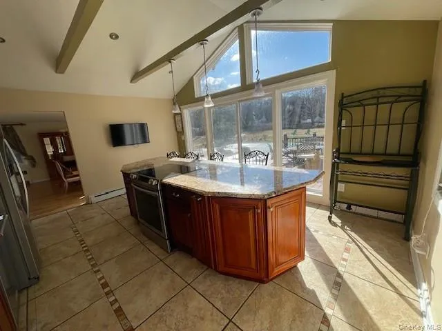 a dining hall with stainless steel appliances granite countertop a sink and cabinets