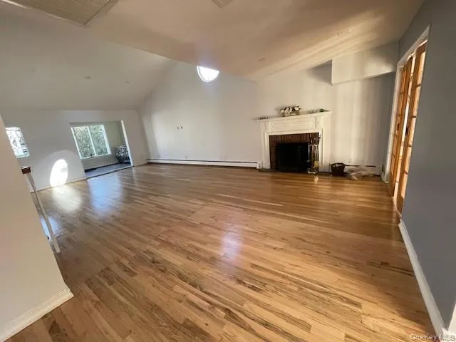 an empty room with wooden floor and fireplace