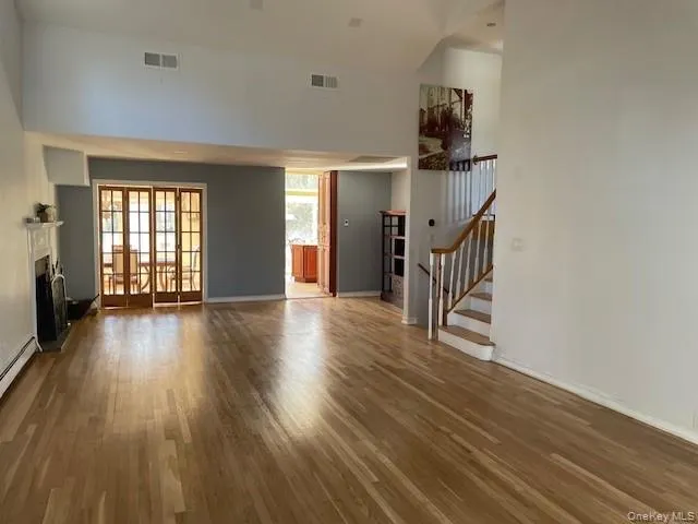 wooden floor fireplace and windows in an empty room