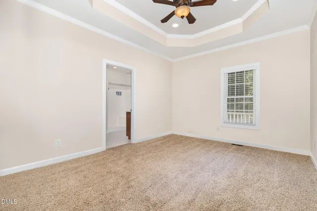 an empty room with fan and mirror