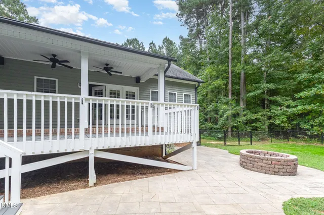 a backyard of a house with plants and large trees