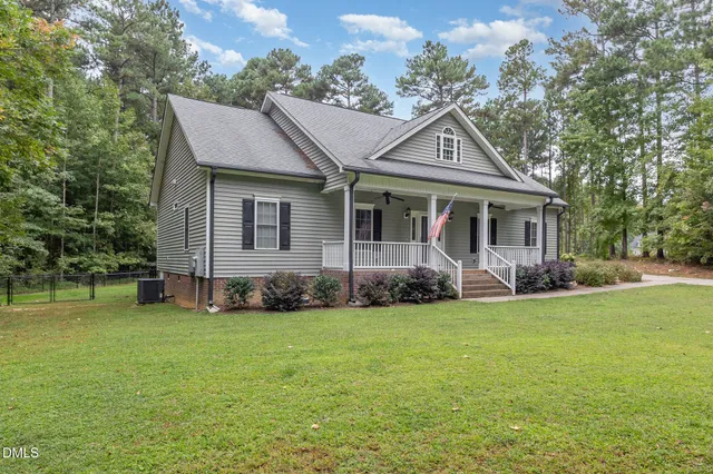 a view of a house with a yard and sitting area