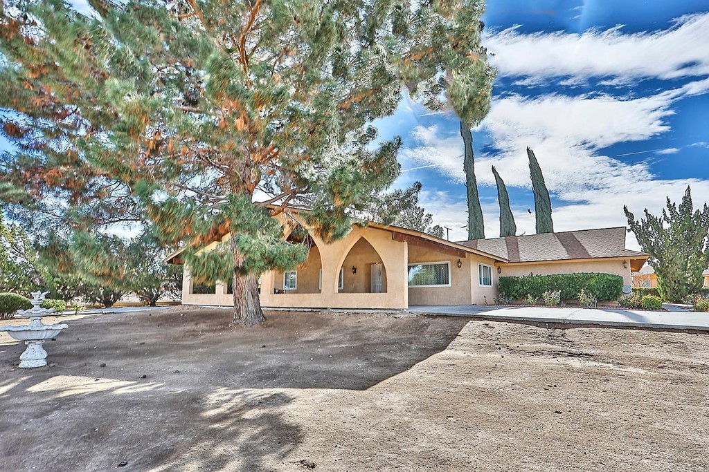 19381 Kinai Road Apple Valley, CA 92307 - Photo 1 of 1 a view of a house with a yard and large trees