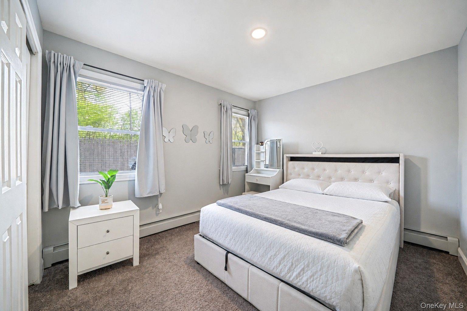 332 Commack Road Shirley, NY 11967 - Photo 16 of 25 a room with a bed and large windows