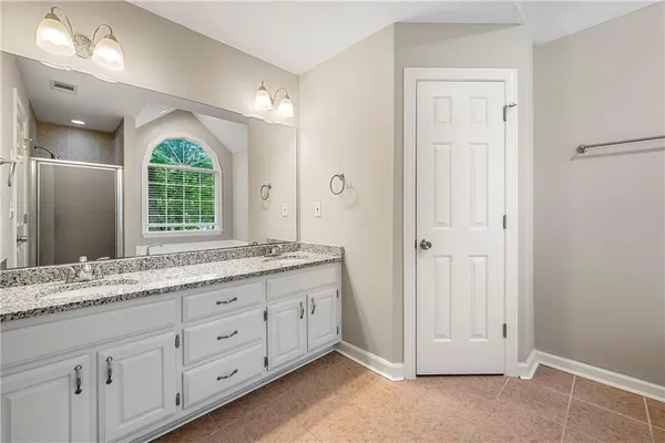 a spacious bathroom with a granite countertop sink mirror and next to a window
