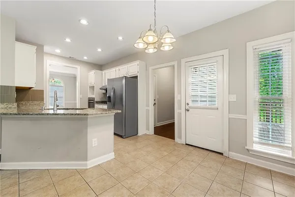 a kitchen with stainless steel appliances granite countertop a refrigerator and a sink