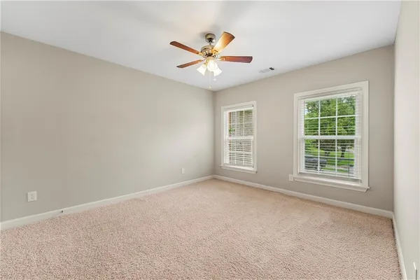 an empty room with window and ceiling fan
