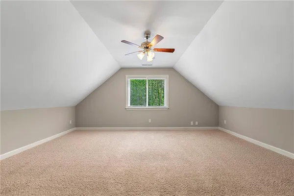 an empty room with windows and chandelier fan