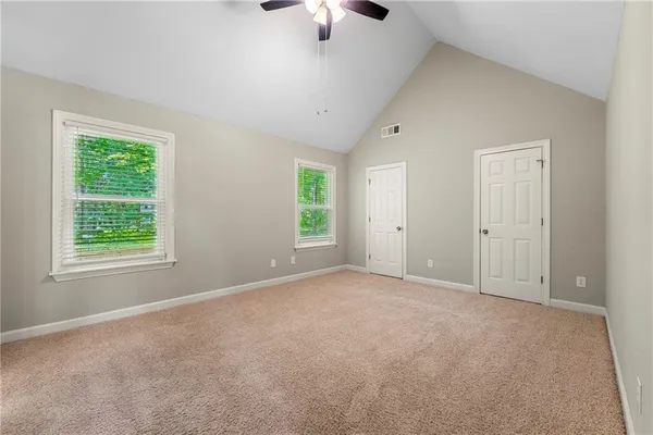 an empty room with ceiling fan and window