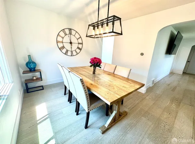 a view of a dining room with furniture and a chandelier