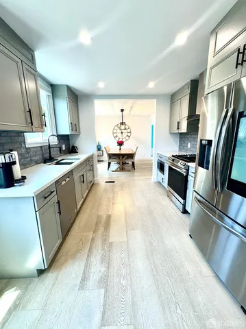 a large kitchen with stainless steel appliances granite countertop a sink dishwasher stove and refrigerator