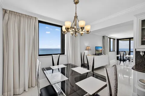 a kitchen that has a table chairs and a refrigerator