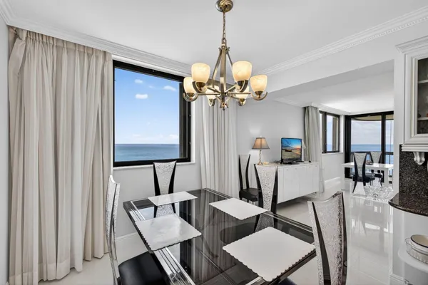 a kitchen that has a table chairs and a refrigerator
