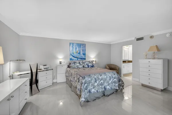 a view of a hallway with wooden floor and a bathroom