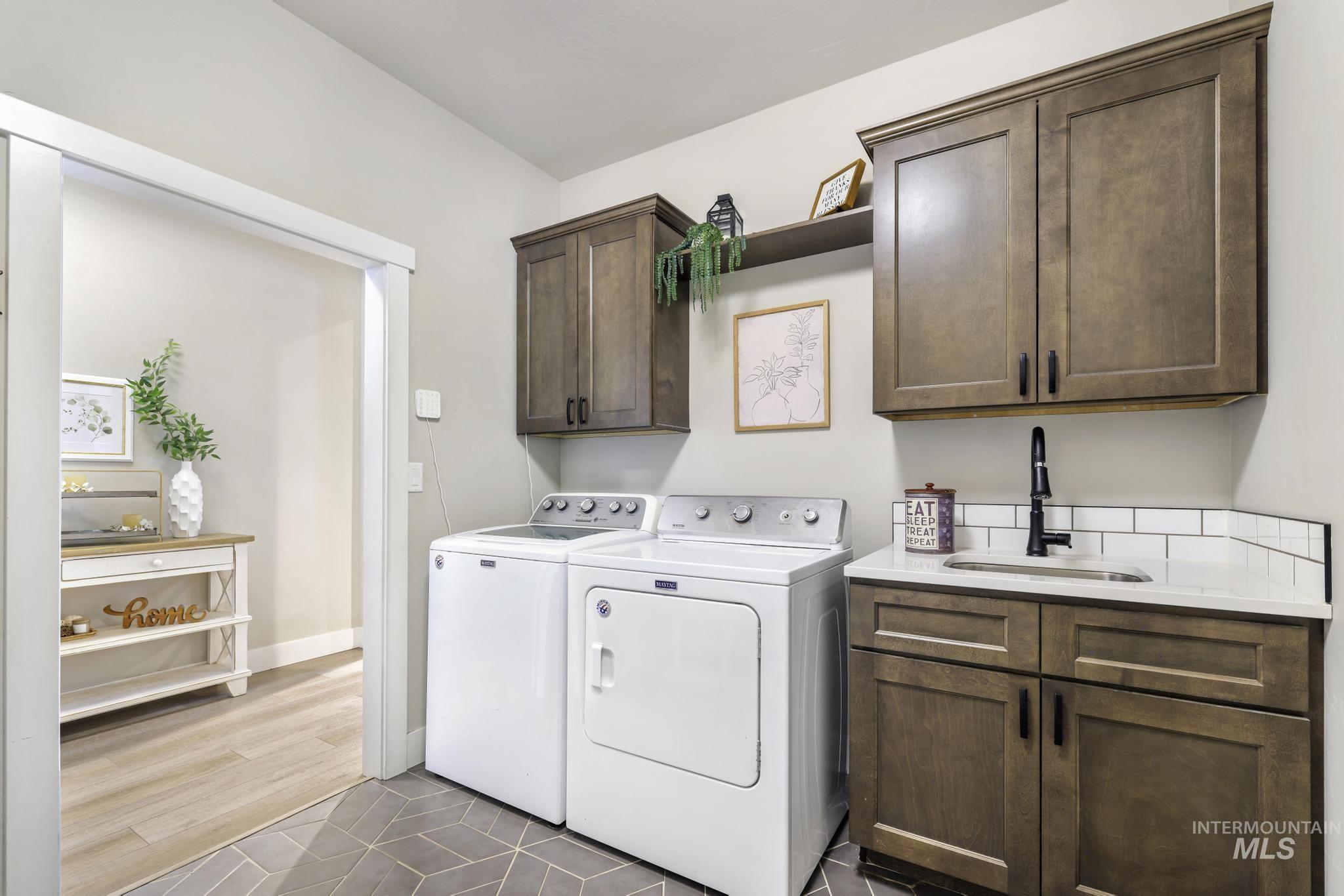 3103 Moonrise Road Twin Falls, ID 83301 - Photo 29 of 40 Laundry area with cabinet space, washing machine and clothes dryer, and dark tile patterned flooring