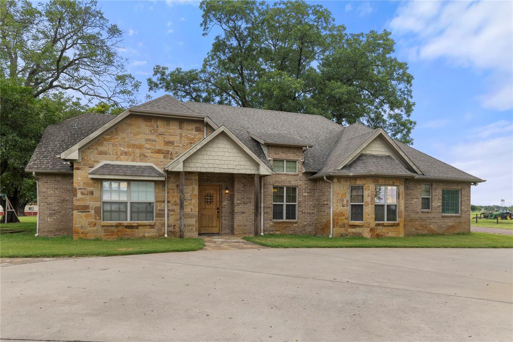 777 Stiles Road Whitesboro, TX 76273 - Photo 6 of 37 a front view of a house with a garden