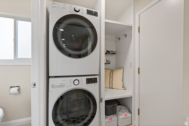 3320 Cherokee Lane Provo, UT 84604 - Photo 17 of 52 Dedicated laundry area featuring a stacked washer and dryer unit, beadboard paneling, integrated shelving, and wall-mounted hooks